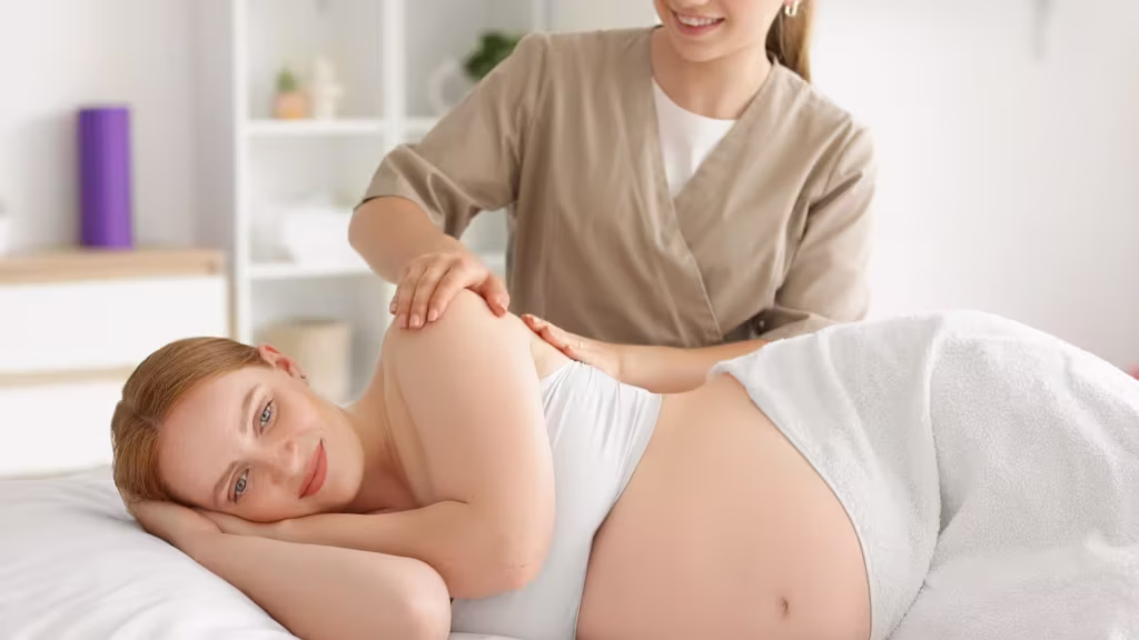 Pregnant woman receiving prenatal massage and wellness care as part of a complete guide to prenatal care from conception to delivery.